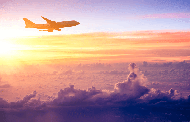 Een vliegtuig boven een zonsondergang op weg naar het buitenland.